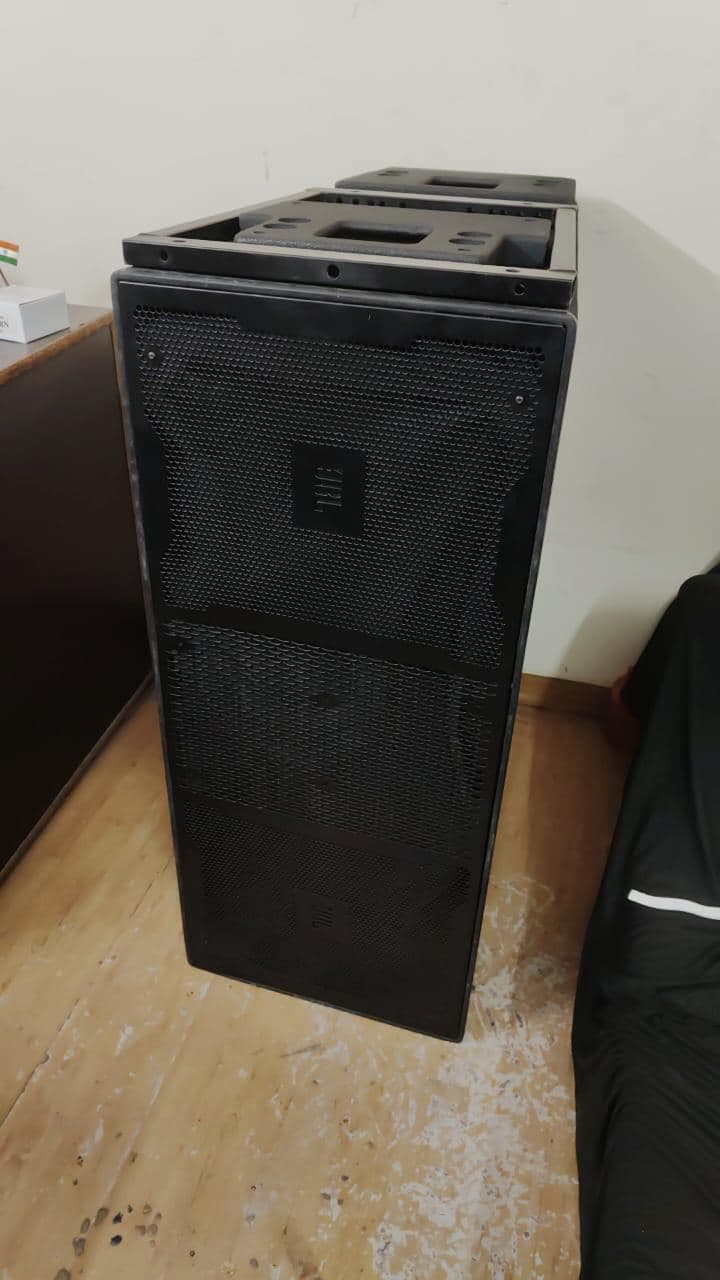 A JBL subwoofer cabinet positioned indoors before a banquet-hall event